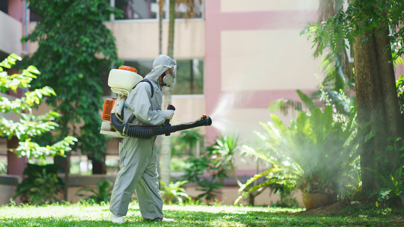 Pest control specialist spraying outdoor garden area – PC Los Angeles