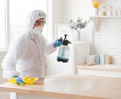 Pest control worker disinfecting kitchen counter – PC Los Angeles