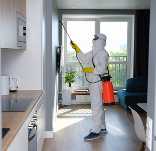 Pest control worker spraying inside apartment – PC Los Angeles
