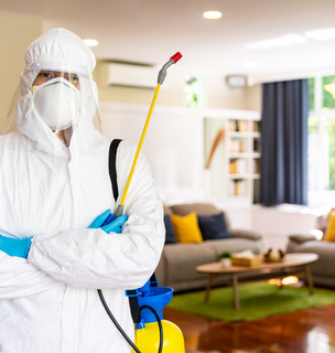 Pest control specialist standing in treated living room – PC Los Angeles