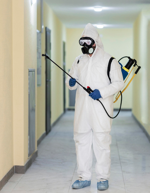 Pest control technician disinfecting apartment hallway – PC Los Angeles